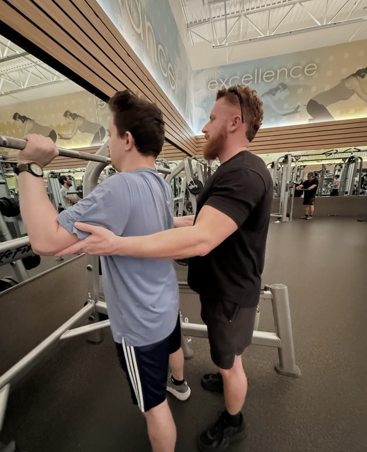 A trainer supporting a participant during a strength exercise